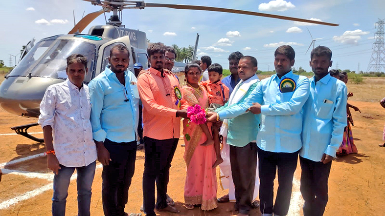 கோவில் கும்பாபிஷேகத்தை பார்க்க  ஹெலிகாப்டரில் வந்த குடும்பத்தினர்- ஆச்சரியத்துடன் பார்த்த கிராமமக்கள்