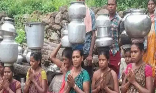 சாலை, குடிநீர் வசதி கேட்டு டோலியை சுமந்து, காலி குடத்துடன் பழங்குடியின மக்கள் நூதன போராட்டம்