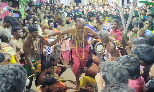 பூக்குழி திருவிழா- அரிவாள் மீது நின்று பக்தர்களுக்கு அருள்வாக்கு கூறிய கோவில் பூசாரி