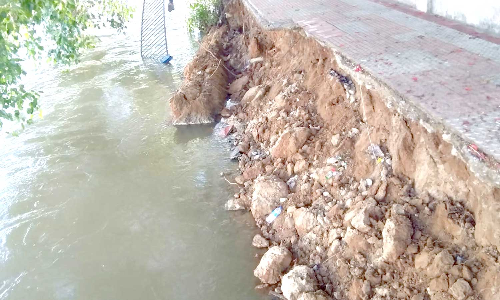 தடுப்பு கம்பிகளுடன் நடைபாதை இடிந்து ஆற்றில் விழுந்தது