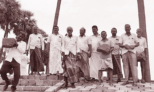 புதிதாக கட்டப்படும் ஏரிக்கரையின் கல்லை பெயர்த்து அதிகாரிகளுடன் விவசாயிகள் வாக்குவாதம்