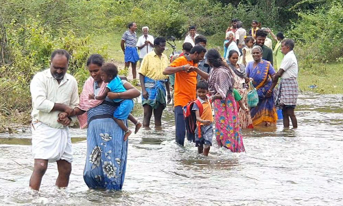 கிருஷ்ணகிரி அருகே ஆபத்தான முறையில்  காட்டாற்று வெள்ளத்தை கடந்து வரும் கிராம மக்கள்