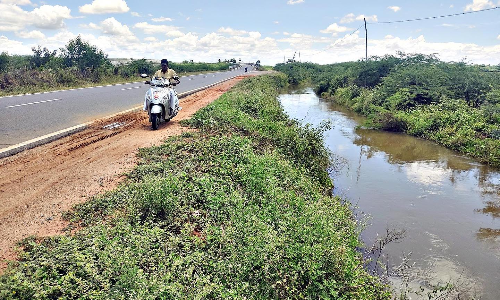 4 வழி சாலையில் தடுப்புசுவர் இல்லாததால் தண்ணீர் செல்லும் கால்வாய்