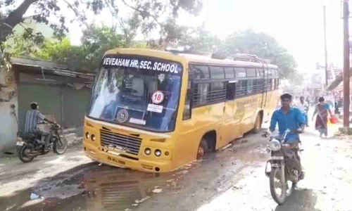 திருப்பூர் காட்டுவலவு பகுதியில் சேறும் சகதியுமான சாலையில் சிக்கிய தனியார் பள்ளி பஸ்