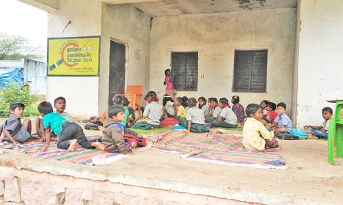 வடமதுரை அருகே கட்டிட வசதி இல்லாததால் நாடக மேடையில் கல்வி பயிலும் குழந்தைகள்