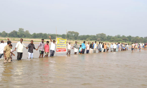 தரைப்பாலம் அமைக்க கோரி பாலாற்றில் இடுப்பளவு தண்ணீரில் இறங்கி கிராம மக்கள் போராட்டம்