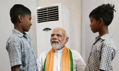 தேர்தல் பிரசாரத்திற்கு நடுவே பழங்குடியின சிறுவர்களை தேடிச்சென்று சந்தித்த பிரதமர் மோடி