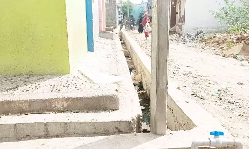 மின்கம்பத்துடன் சேர்த்து கட்டப்பட்ட கழிவு நீர் கால்வாய்