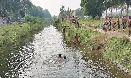 திட்டக்குடி அருகே ஆபத்தை உணராமல் வாய்க்காலில் குளிக்கும் வாலிபர்கள்