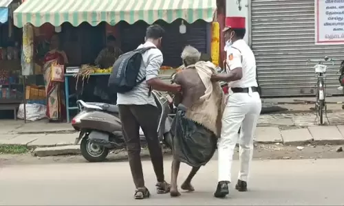 காரைக்கால் புதிய பஸ் நிலையம் எதிரே சாலையை கடக்க முடியாமல் தவித்த முதியவருக்கு உதவிய போலீசார்