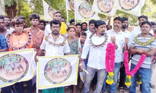 கழுத்தில் மணியை கட்டிக்கொண்டு ஜல்லிக்கட்டு வீரர்கள் நூதன ஆர்ப்பாட்டம்