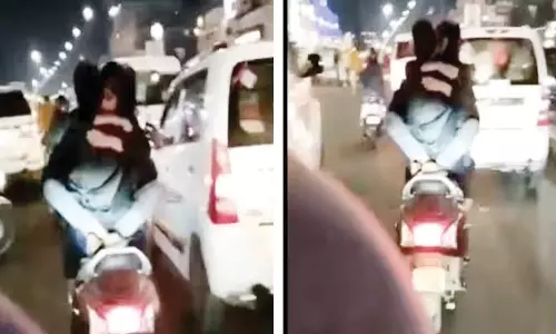 காதலியை முன்னால் அமர வைத்து நடுரோட்டில் ஸ்கூட்டரில் சென்றவாறு கட்டிப்புடி சாகசம் செய்த காதலன்