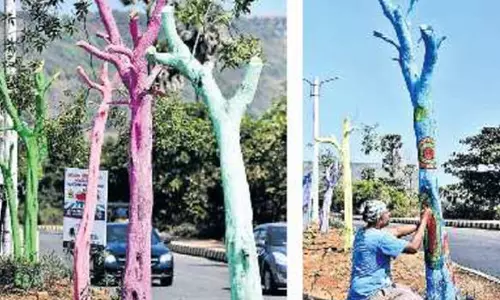 முதல்வர் வருகைக்காக மரக்கிளைகளை வெட்டி வண்ணம் தீட்டும் பணி- எதிர்ப்பு தெரிவித்து வியாபாரிகள் கடையடைப்பு