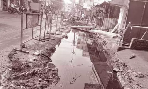 மழைநீர் கால்வாய் பணி முடியாததால் தண்ணீர் தேக்கம்- கொசுவுக்கு பயந்து கடைகளை மூடும் வியாபாரிகள்