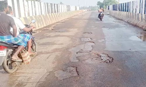 குண்டும் குழியுமான மேம்பால சாலையை சீரமைக்க வேண்டும்