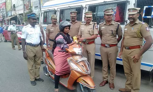 நெல்லையில் பெண் வாகன ஓட்டிகளுக்கு திருக்குறள்  புத்தகங்களை பரிசளித்த போலீசார்
