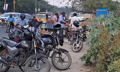 சிங்காநல்லூர் உழவர் சந்தையில் நடுரோட்டில் நிறுத்தப்படும் மோட்டார் சைக்கிள்கள்