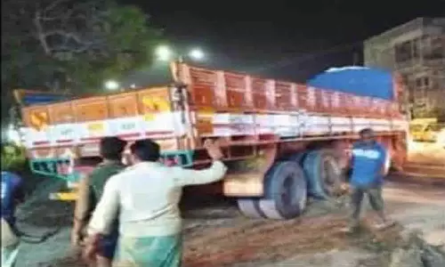 எரிவாயு குழாய் பதிக்க தோண்டப்பட்ட குழியில் சிக்கிய லாரி