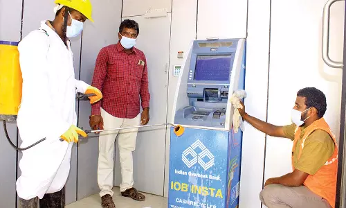 கொரோனா பரவலை தடுக்க நடவடிக்கை- நெல்லையில், ஏ.டி.எம். எந்திரங்களில் கிருமி நாசினி தெளிப்பு