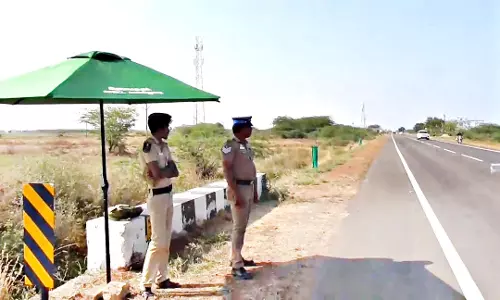சாலையோர பாதுகாப்பு பணியில் நிற்கும் போலீசாருக்கு தற்காலிக நிழற்குடை
