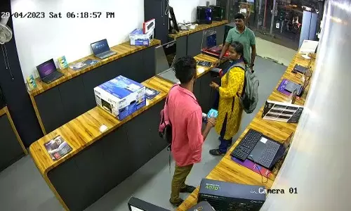 கடையில்  லேப்-டாப்பை திருடி பையில் திணித்த இளம்பெண்