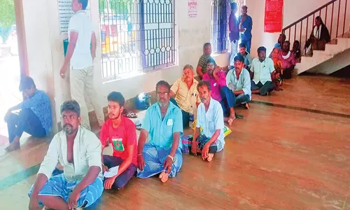 நெல்லை சந்திப்பு ரெயில் நிலையத்தில் தட்கல் டிக்கெட் எடுப்பதற்காக தரையில் வரிசையாக அமர்ந்திருக்கும் பயணிகள்