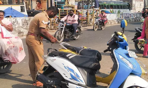 கடலூர் உழவர் சந்தை முன்பு  சாலையில் தாறுமாறாக நிறுத்திய வாகனங்களுக்கு பூட்டு :  போக்குவரத்து போலீசார் நடவடிக்கை