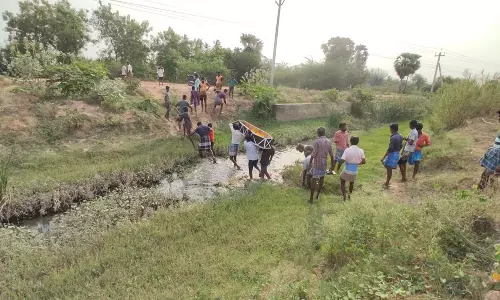 குறிஞ்சிப்பாடி அருகே வாய்க்காலில் பிணத்தை சுமந்து செல்லும் அவலம்:  பாலம் கட்டித் தர கோரிக்கை