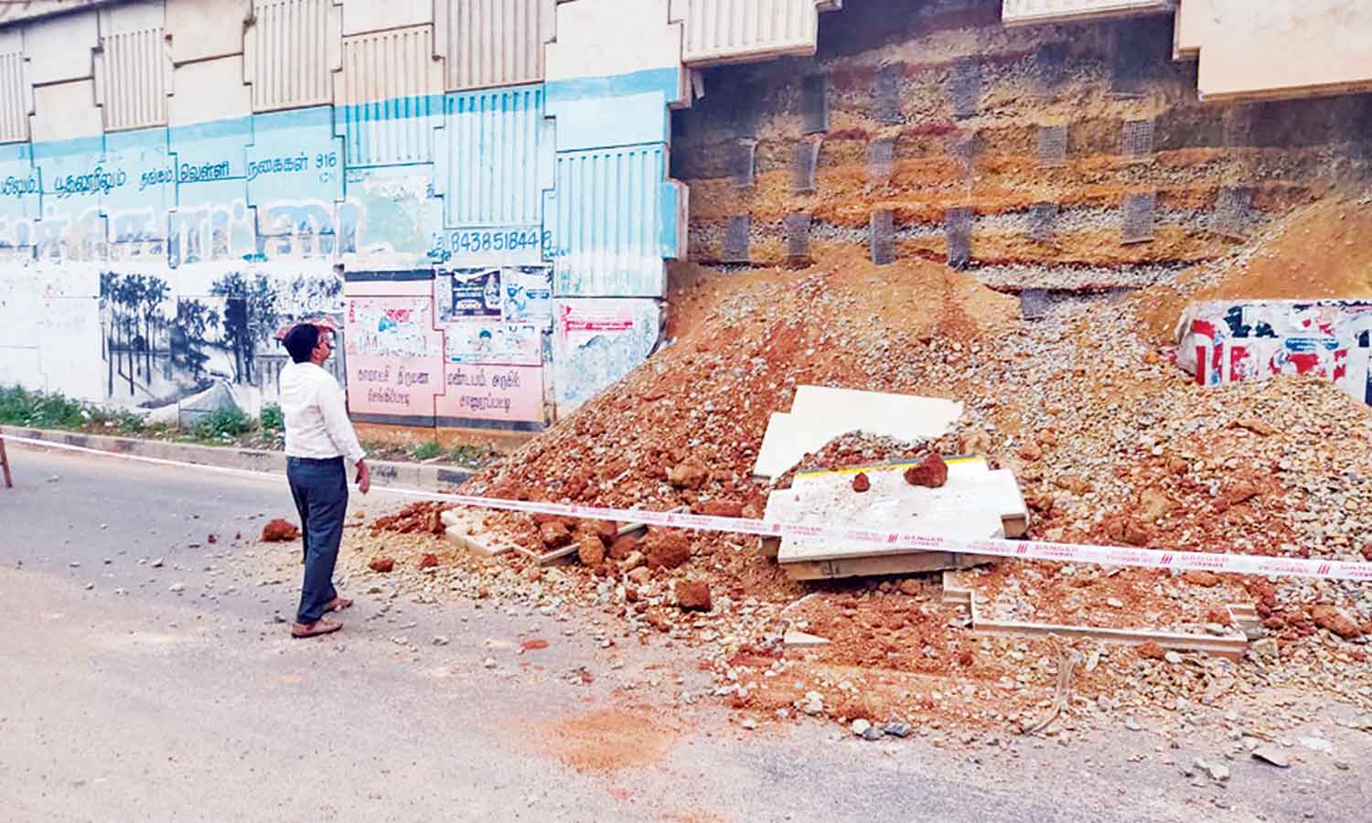 திடீரென சரிந்து விழுந்த உயர்மட்ட பாலத்தின் பக்கவாட்டு சுவர்- பஸ்சை வழிமறித்து பொதுமக்கள் சாலைமறியல்