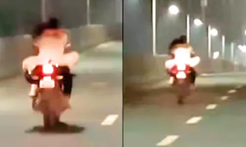 ஓடும் மோட்டார் சைக்கிளில் காதல் ஜோடியின் ரொமான்ஸ்