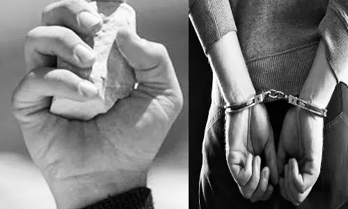 அரிசி ஆலை காவலாளியை கல்லால் தாக்கிய தந்தை- மகன் கைது