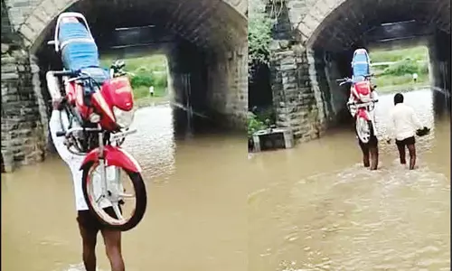 மோட்டார் சைக்கிளை தலையில் சுமந்து சென்ற பாகுபலி வாலிபர்: சமூக வலைத்தளங்களில் வைரல்