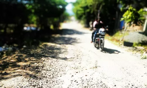 குண்டும், குழியுமான சாலையால் பள்ளி மாணவர்கள் அவதி