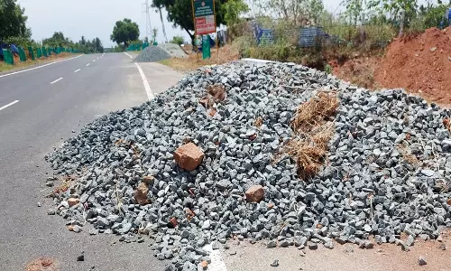 இடையக்கோட்டை அருகே சாலையில் கொட்டிக்கிடக்கும் மணல், ஜல்லிகளால் விபத்து அபாயம்