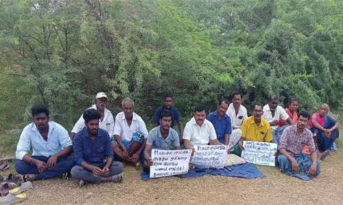 திருச்செங்கோடு அருகே சாலை அமைக்க கோரி ஏரிக்குள் அமர்ந்து போராட்டம்