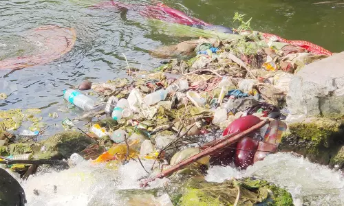 ஒகேனக்கல்லில் குவியல் குவியலாக கிடக்கும் துணிகளை அகற்ற வேண்டும்