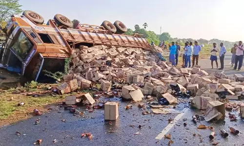 பீர் பாட்டில்களுடன் நடுரோட்டில் கவிழ்ந்த லாரி- பாட்டில்களை அள்ளிச்சென்ற பொதுமக்கள்