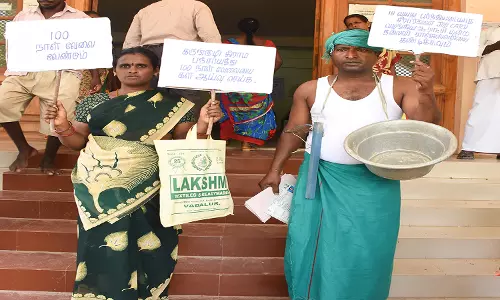 கழுத்தில் சில்வர் பாத்திரம், மண்வெட்டியை மாலையாக அணிந்து கலெக்டர் அலுவலகத்திற்கு மனு அளிக்க வந்த கணவன், மனைவி