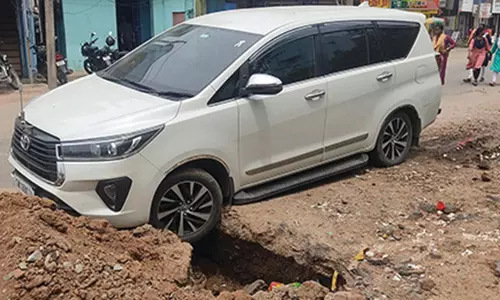 பாதாள சாக்கடை திட்டப் பணிக்காக தோண்டப்பட்ட பள்ளத்தில் விழுந்த கார்- அதிர்ஷ்டவசமாக உயிர் தப்பிய டிரைவர்