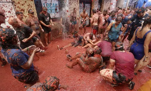 சிவப்பாக மாறிய ஸ்பெயினின் நகரம்- ஒருவர் மீது ஒருவர் தக்காளியால் அடித்துக்கொள்ளும் வினோத திருவிழா