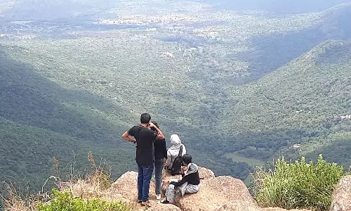 சோலூர் காட்சிமுனையில் மலையின் விளிம்பில் நின்று செல்பி எடுக்கும் பயணிகள்