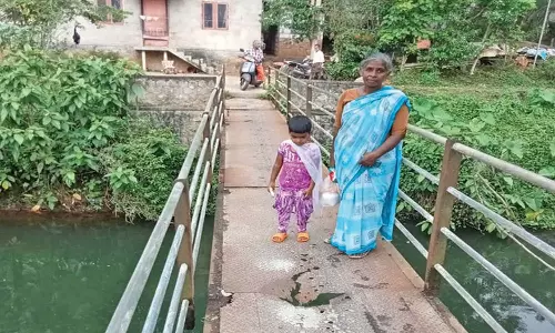 இரும்பு பாலத்தின் மீது அச்சத்துடன் நடந்து செல்லும் மாணவ-மாணவிகள்