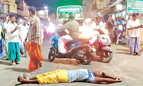 நடுரோட்டில் படுத்து கிடந்து போலீசாரிடம் தகராறில் ஈடுபட்ட போதை வாலிபர்