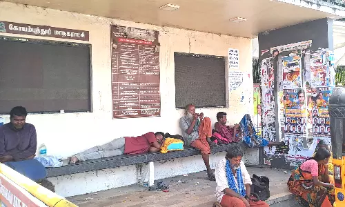 கோவை டவுன்ஹாலில் பயணிகளுக்கு இடம்கொடுக்காமல் பஸ் நிறுத்தத்தில் தூங்கும் போதை கும்பல்
