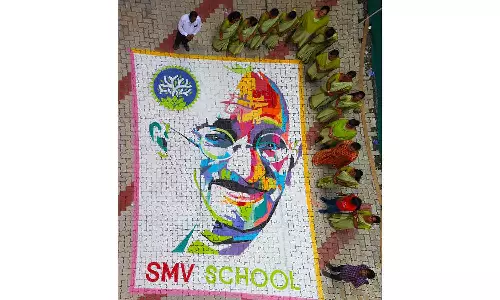 எஸ்.எம்.வி.பள்ளியில் வண்ணப்பொடிகளை கொண்டு காந்தியின் உருவப்படத்தை வரைந்த மாணவர்கள்