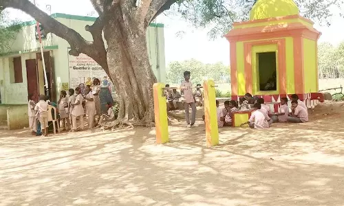 போதிய வகுப்பறைகள் இல்லாததால் மரத்தடியில் கல்வி பயிலும் மாணவ-மாணவிகள்