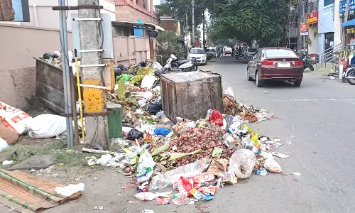 பூ மார்க்கெட் அருகே நடு ரோட்டில் குவிந்து கிடக்கும் குப்பைகள்