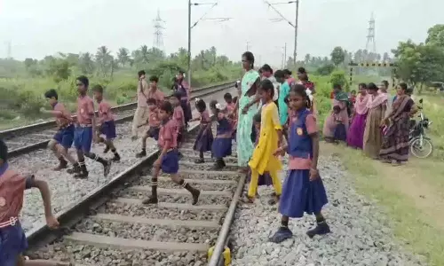 தண்டவாளத்தை கடந்து செல்லும் பள்ளி குழந்தைகள்