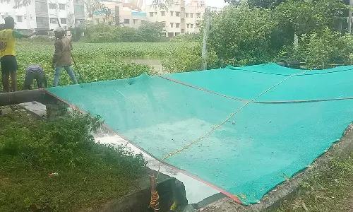 புத்தேரி ஏரியில் நுரையாக வெளியேறும் தண்ணீரை வலைபோட்டு மறைத்த அதிகாரிகள்