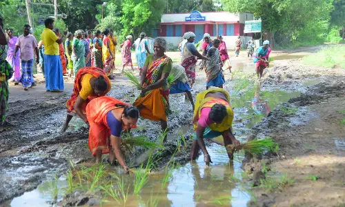 சேரும்-சகதியுமான சாலையில் நாற்று நட்டு பெண்கள் போராட்டம்